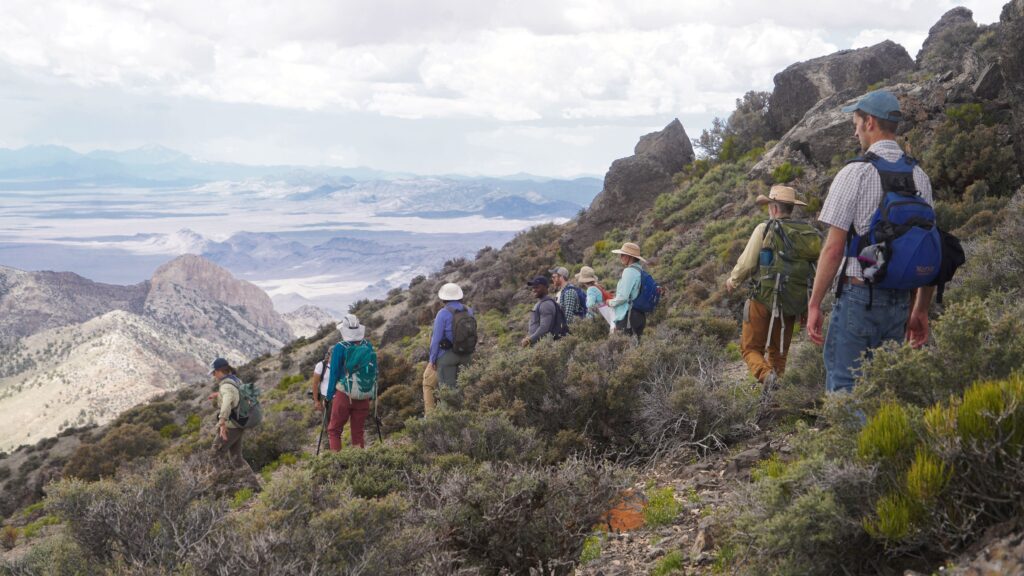 People hiking down a mountain slope